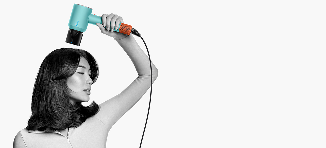 Женщина укладывает волосы с помощью насадки-концентратора Dyson