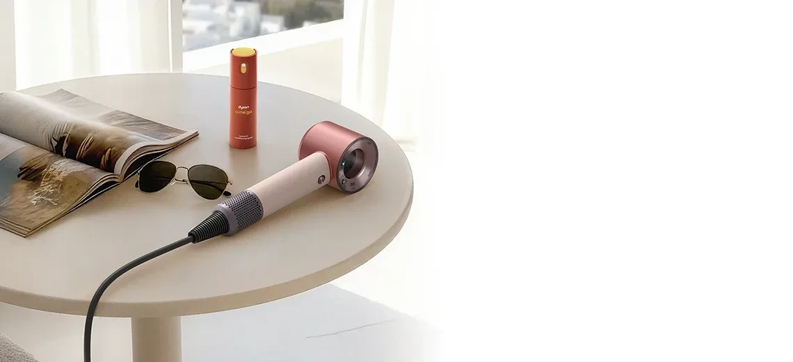 Фен Dyson Supersonic Travel на столе у окна